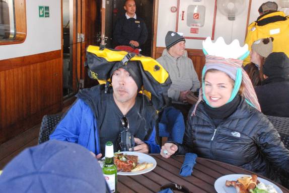 Nossos disfarces no almoço festivo de chapéus criativos no deck do Sea Spirit, na baía de Deception Island, na Antártida (foto de Senteney)